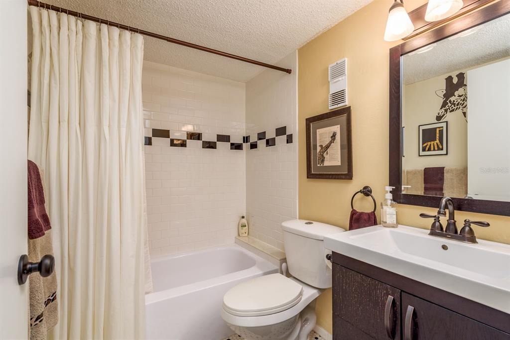 952 Virginia Street, Unit 105 Dunedin, FL 34698 - Photo 15 of 26 a bathroom with a sink a toilet and shower