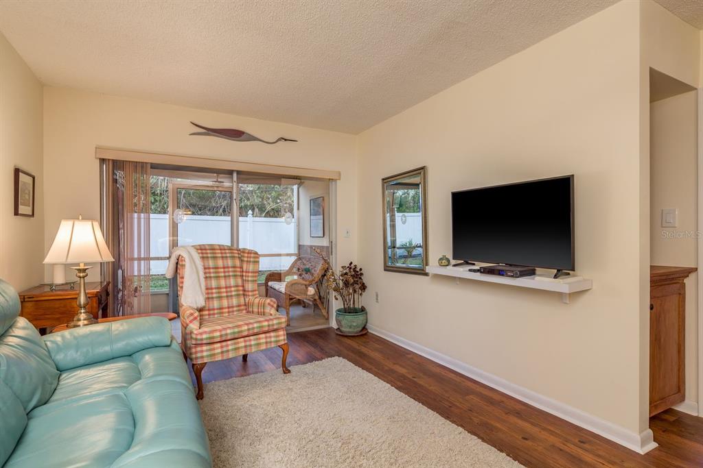 952 Virginia Street, Unit 105 Dunedin, FL 34698 - Photo 8 of 26 a living room with furniture and a flat screen tv