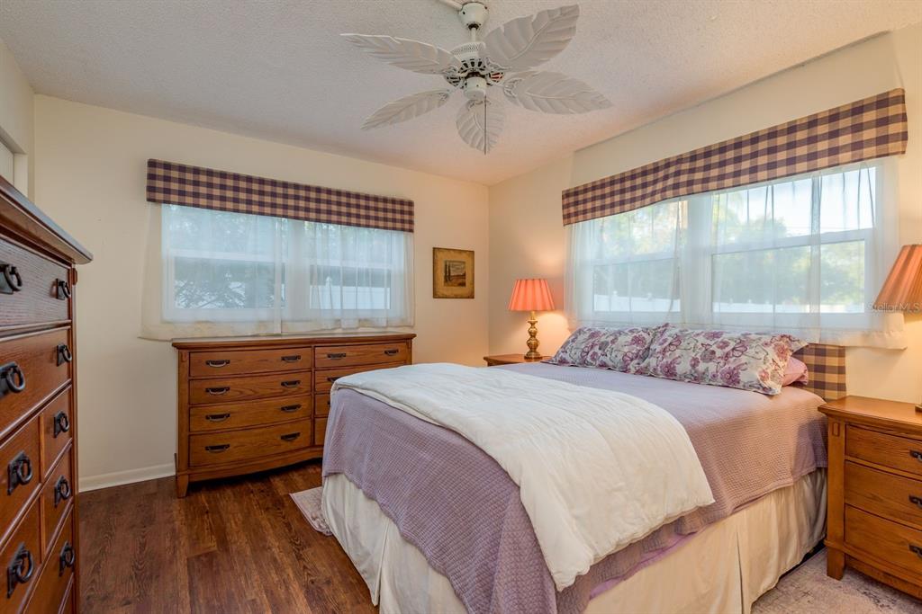 952 Virginia Street, Unit 105 Dunedin, FL 34698 - Photo 10 of 26 a bedroom with a bed a dresser and a large window