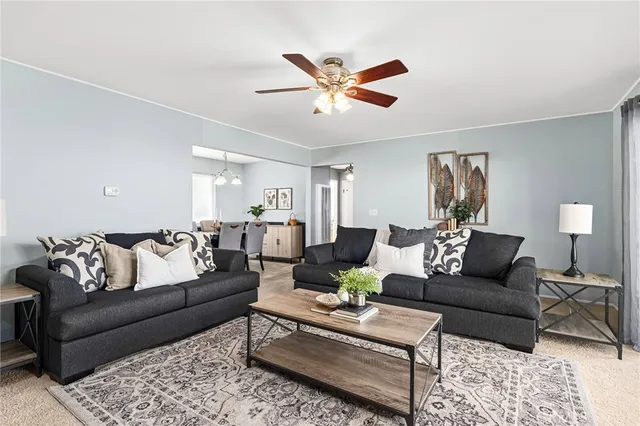 a living room with furniture and a ceiling fan