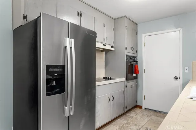 a kitchen with stainless steel appliances a refrigerator and cabinets