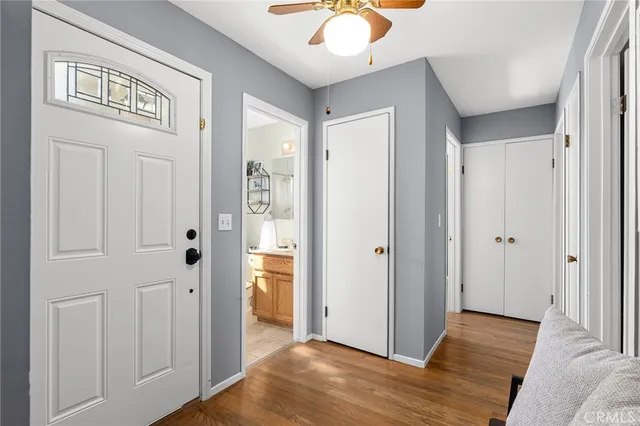 a view of a hallway with wooden floor and cabinet with a mirror