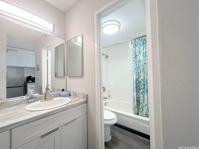 a bathroom with a granite countertop sink toilet and shower