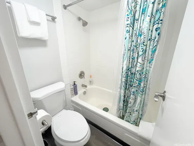 a white toilet sitting next to a bath tub