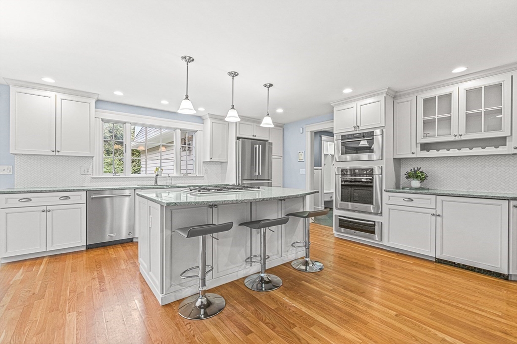 24 Birch Road Wellesley, MA 02482 - Photo 14 of 40 a kitchen with stainless steel appliances granite countertop a stove a sink and white cabinets with wooden floor