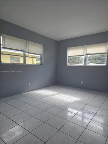 an empty room with entrance and windows