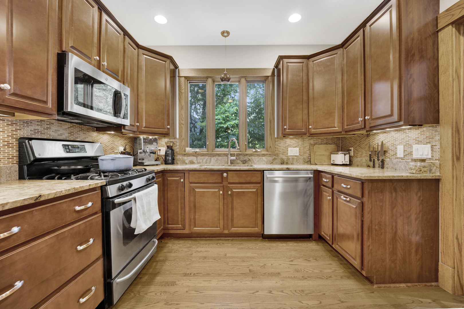 103 Pine Avenue Riverside, IL 60546 - Photo 10 of 42 a kitchen with stainless steel appliances granite countertop a stove a sink and a microwave