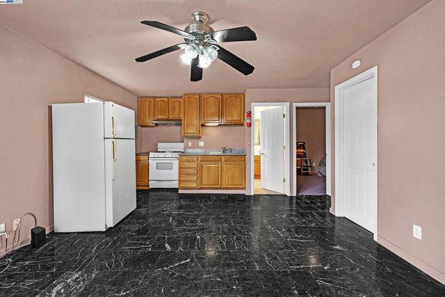 a view of a kitchen with a sink and refrigerator