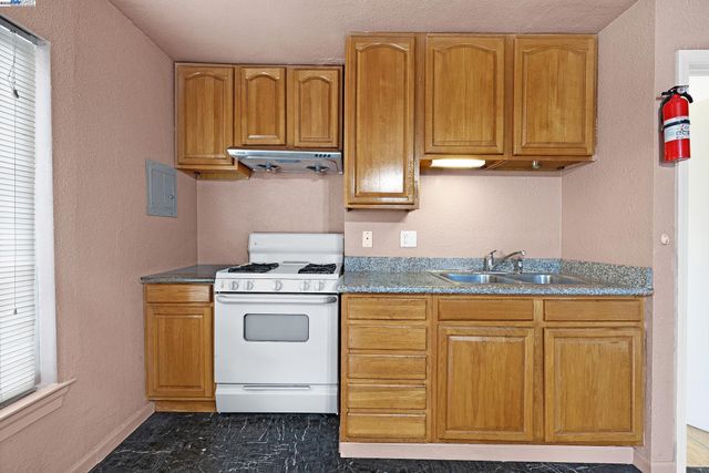 a kitchen with granite countertop cabinets stainless steel appliances and a counter space