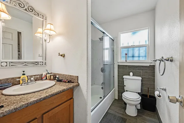 a bathroom with a granite countertop sink toilet and shower