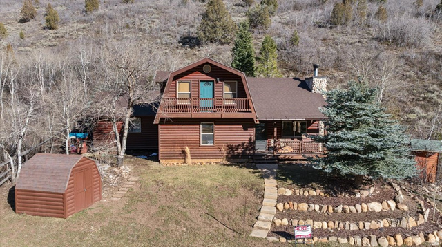 438 Beaver Creek Road, Unit 438 Kamas, UT 84036 - Photo 1 of 1 Back of house featuring a balcony, a gambrel roof, a shed, a chimney, and a shingled roof