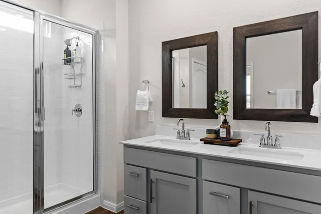 a bathroom with double vanity sinks and a mirror