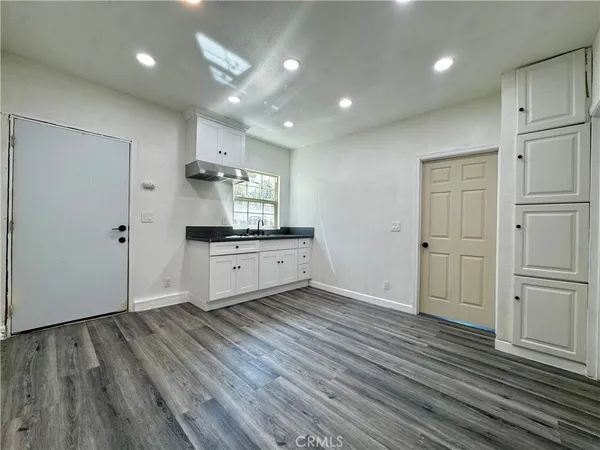 a large kitchen with a wooden floor and windows