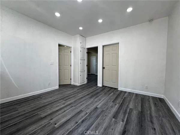 an empty room with wooden floor and closet