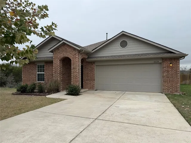 a front view of a house with yard and garage