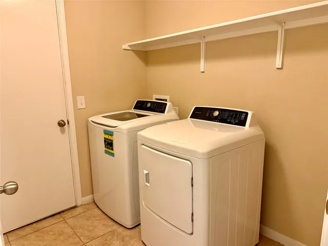 a view of a hallway with wooden floor and a bathroom