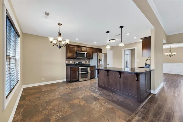 a large kitchen with kitchen island a large counter space and stainless steel appliances