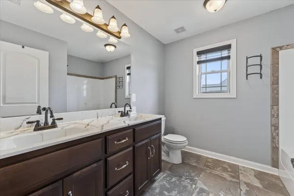 a bathroom with a double vanity sink toilet and a mirror