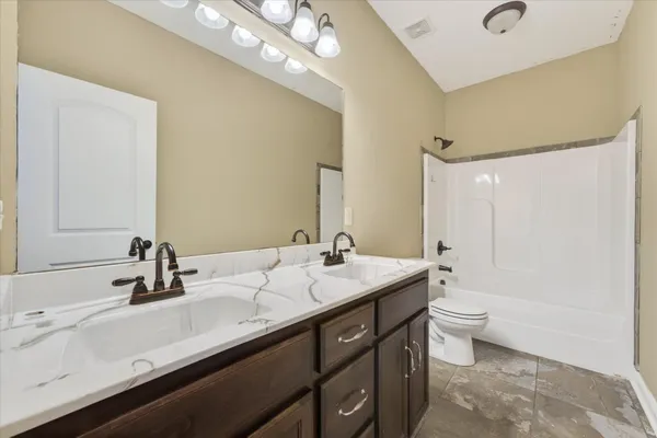 a bathroom with a double vanity sink mirror double and toilet