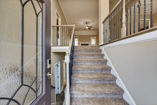 a view of staircase with lots of frames on wall and a window
