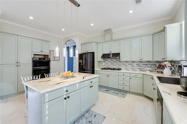 a kitchen that has a sink a stove counter space and cabinets