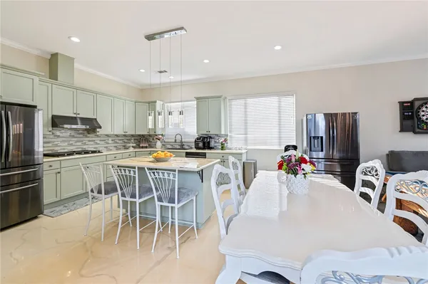a kitchen with refrigerator a sink and chairs