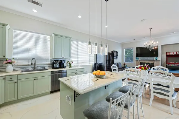 a kitchen with stainless steel appliances a table chairs and a sink