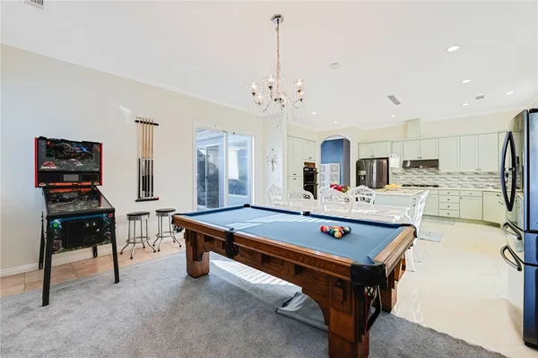 a room with pool table flat screen tv and windows