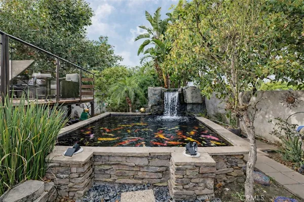 a view of a backyard with potted plants and large trees