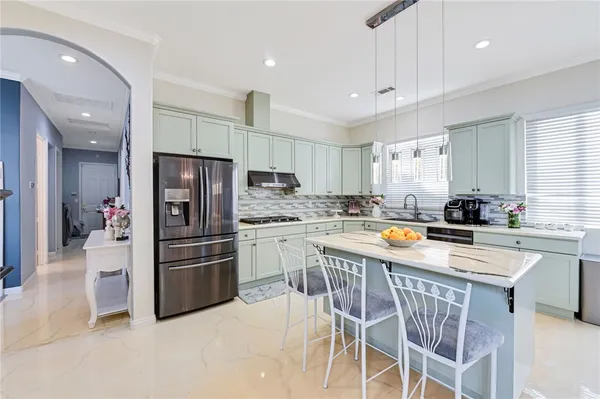 a kitchen with stainless steel appliances a refrigerator a stove a sink and white cabinets