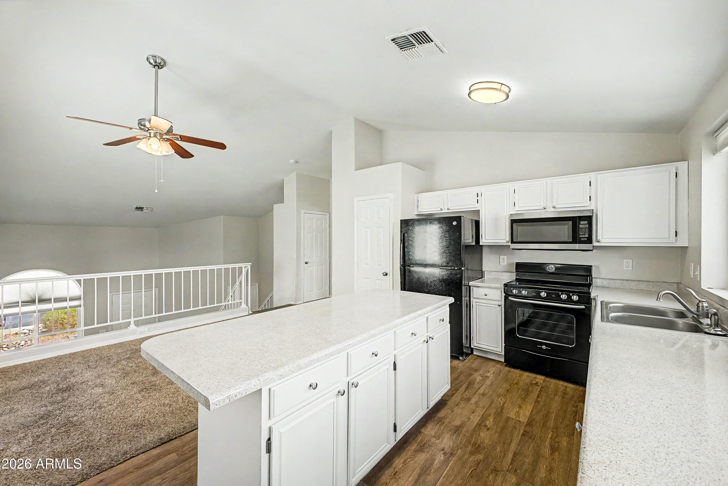 3134 East McKellips Road, Unit 221 Mesa, AZ 85213 - Photo 9 of 29 a kitchen with a refrigerator a stove top oven a sink dishwasher and white cabinets with wooden floor