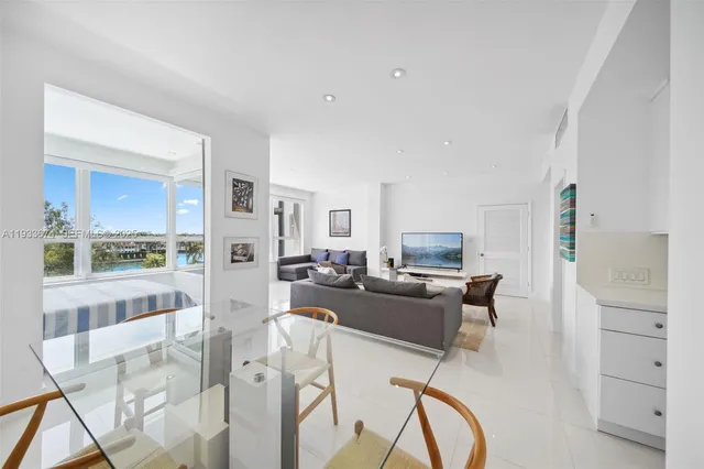 a living room with furniture a rug and kitchen view