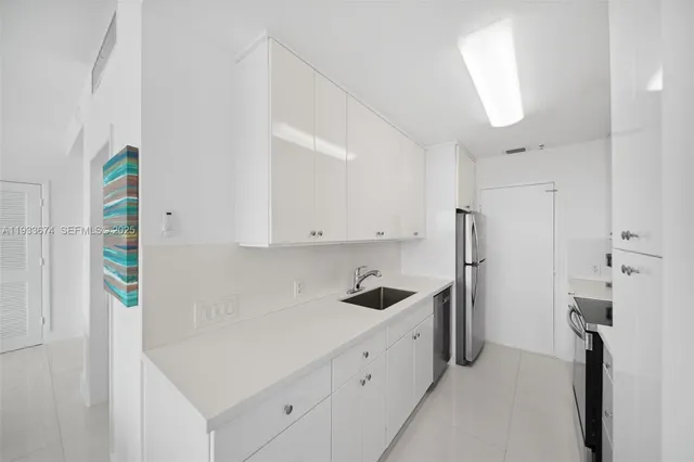 a kitchen with cabinets and a stainless steel refrigerator
