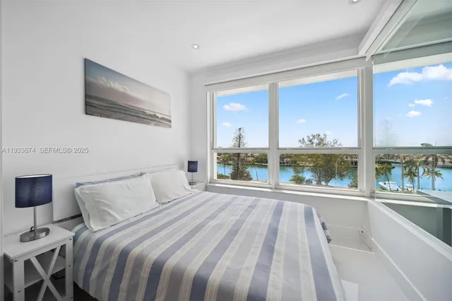 a bedroom with a bed and a large window