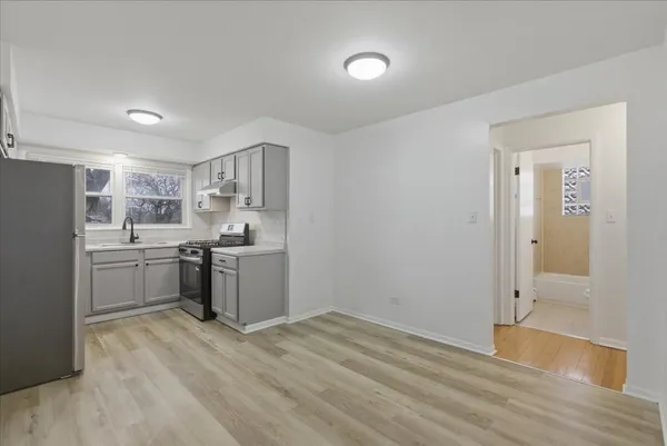 a kitchen with a refrigerator sink and cabinets