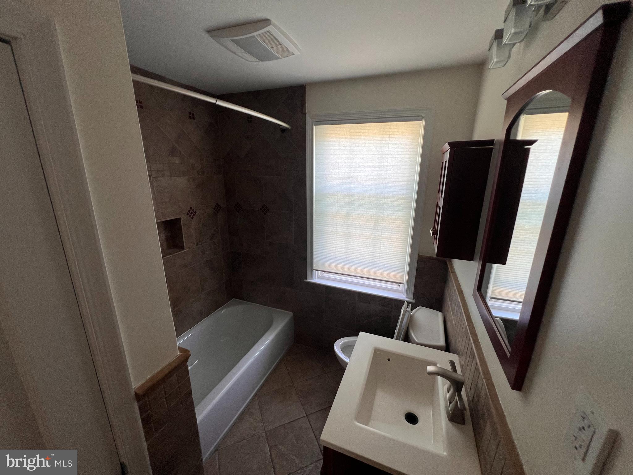 1583 Doxbury Road Towson, MD 21286 - Photo 17 of 31 a bathroom with a sink a toilet a window and tub