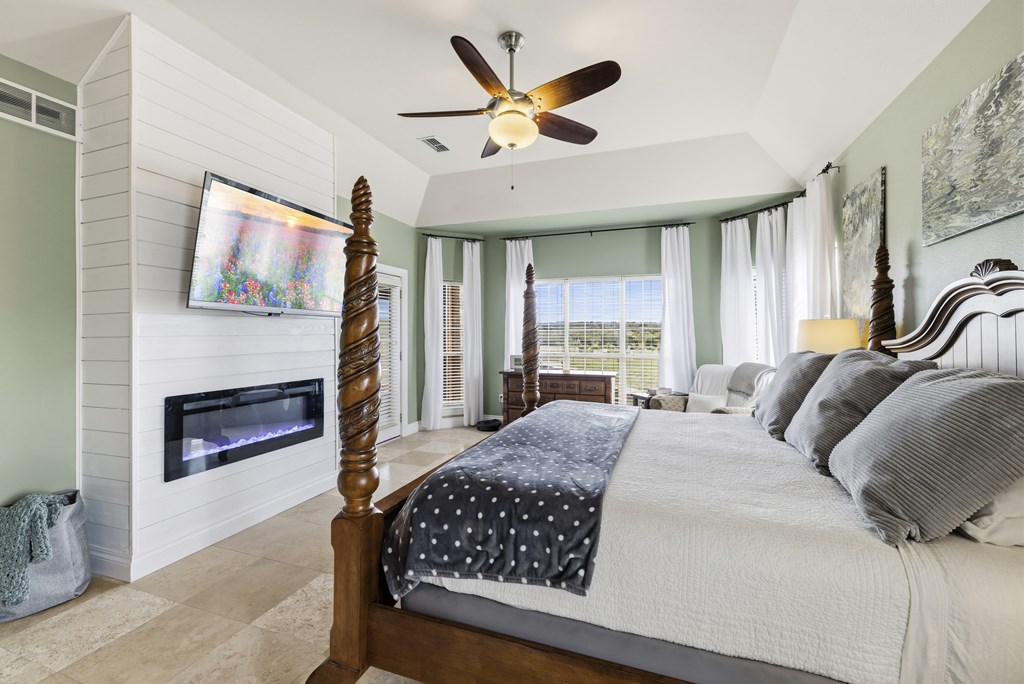 360 Bluff Creek Road North Center Point, TX 78010 - Photo 14 of 64 a bedroom with a bed and a fireplace