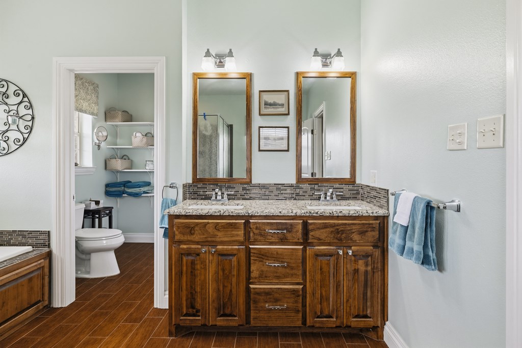 360 Bluff Creek Road North Center Point, TX 78010 - Photo 17 of 64 a bathroom with a granite countertop sink a toilet and a mirror