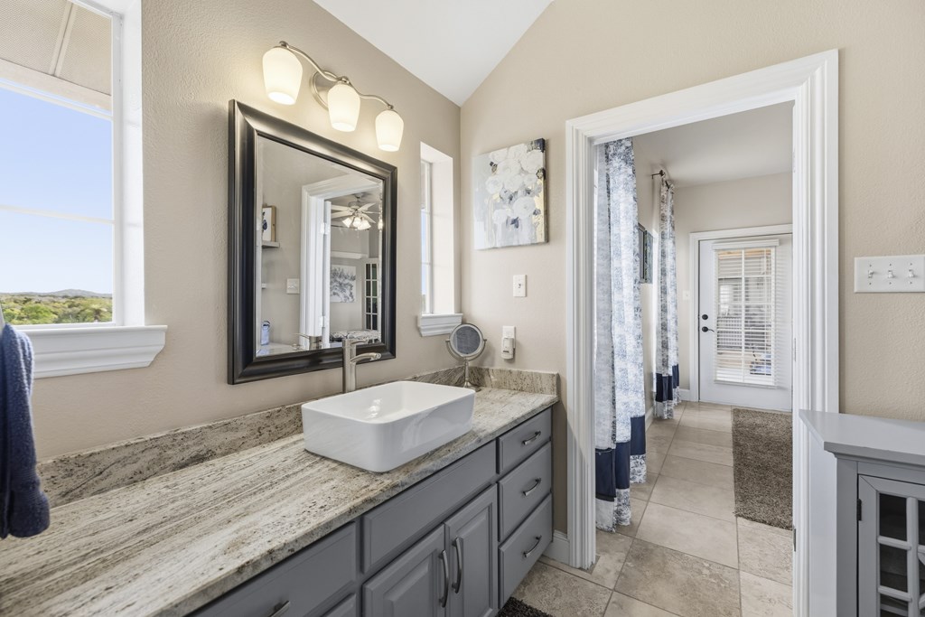 360 Bluff Creek Road North Center Point, TX 78010 - Photo 21 of 64 a spacious bathroom with a granite countertop sink and a mirror