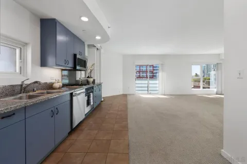 a large kitchen with kitchen island granite countertop a sink a counter top space and stainless steel appliances