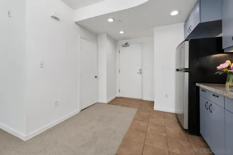 a view of hallway with stainless steel appliances granite countertop cabinets and a sink
