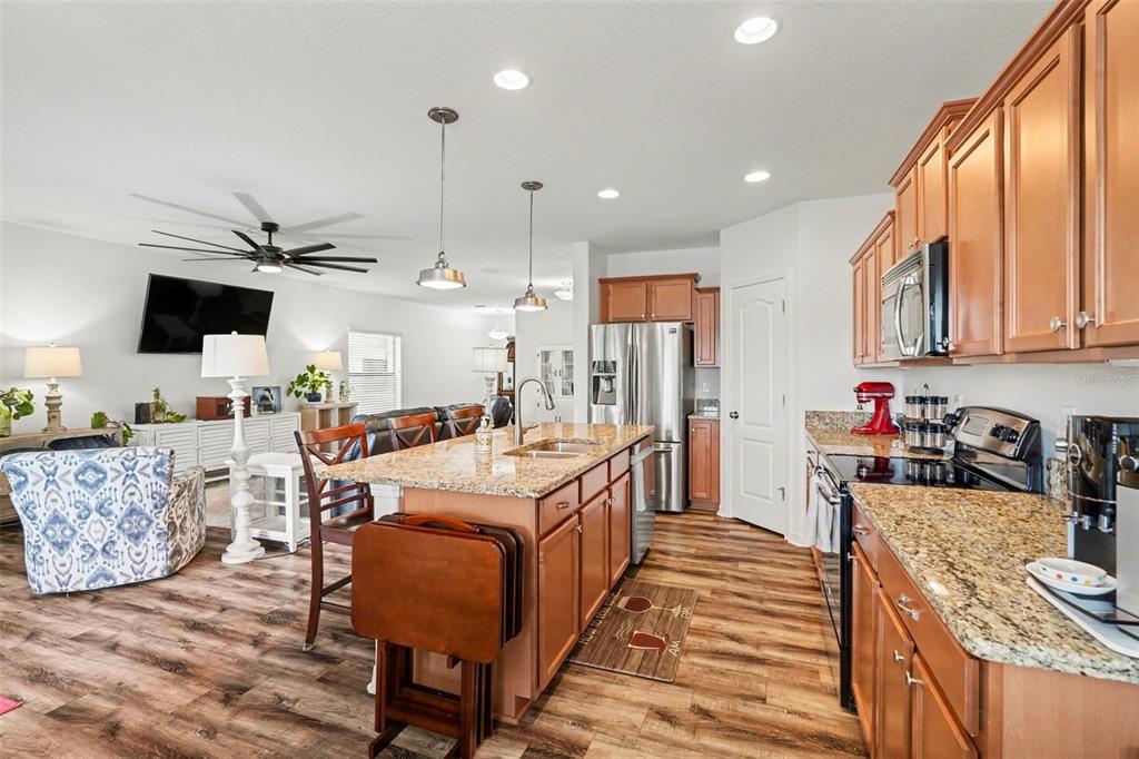 1606 Acadia Harbor Place Brandon, FL 33511 - Photo 12 of 38 a large white kitchen with stainless steel appliances granite countertop a stove and a view of living room