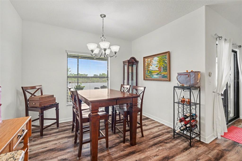 1606 Acadia Harbor Place Brandon, FL 33511 - Photo 13 of 38 a view of a dining room with furniture wooden floor and chandelier