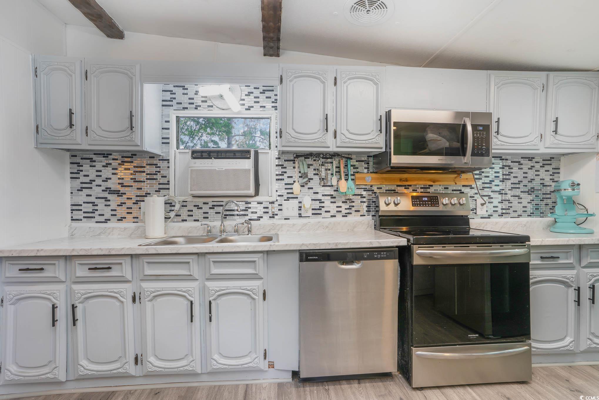 127 Offshore Drive Murrells Inlet, SC 29576 - Photo 4 of 40 Kitchen with stainless steel appliances, tasteful backsplash, and light countertops