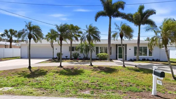 a row of palm trees and a swimming pool in the backyard of a house
