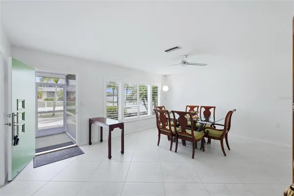 a kitchen with stainless steel appliances granite countertop a stove a sink dishwasher a dining table and chairs with wooden floor