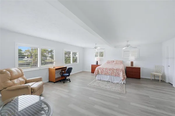 a spacious bedroom with a bed a table and chair