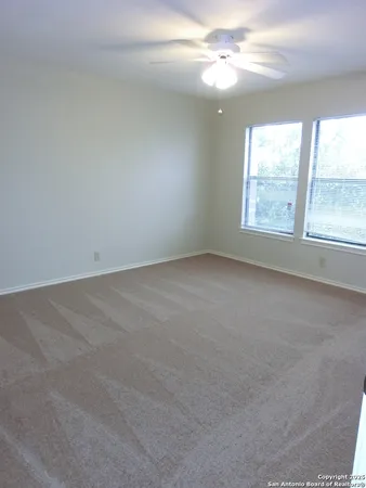 an empty room with a window and a fan