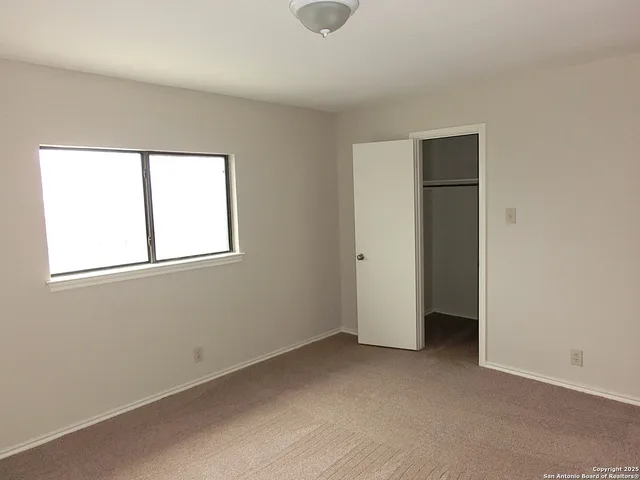an empty room with windows and closet