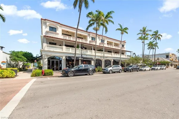 a front view of a building with palm trees
